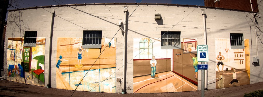 This final mural illustrates the historical and cultural importance of Milton’s YMCA, depicting many of the services used by patrons over the decades. It is split into four different parts, the first depicting a classroom scene with young children learning and playing. This atmosphere is one that Snyder is very familiar with, as she is accustomed to working with kids on her large murals, related projects, and smaller mural exchanges. In working with children, Snyder has come to realize that they are born without any inherent hate, judgment, or malice but rather are truly innocent, kind, and genuinely friendly. Snyder reinforces this type of behavior by allowing children to help her in the creation of her pieces.